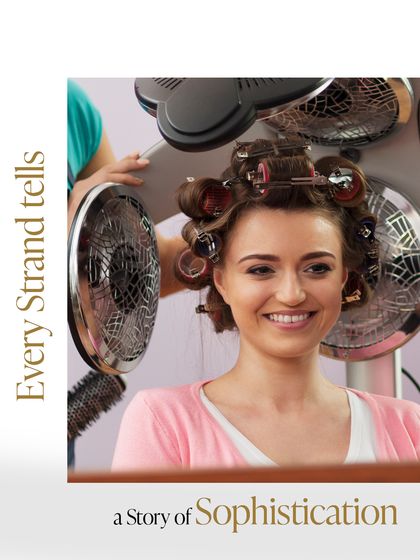 Every strand tells a story of sophistication. A client relaxes under the dryer as her curls are set, a classic technique for achieving voluminous, long-lasting style.