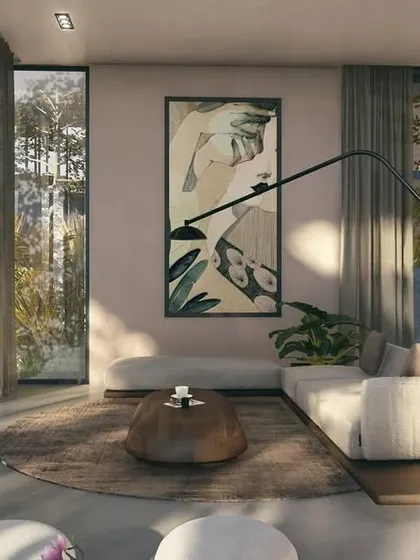 Another view of the Moira Homes living area, showcasing how the space opens directly onto the pool deck. The design uses a neutral, earthy palette to complement the lush tropical landscape visible through the large glass doors.
