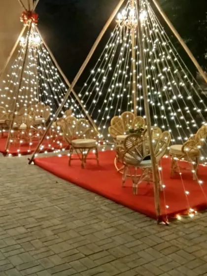 A creative and cozy seating idea with teepee-like structures made of bamboo and fairy lights.