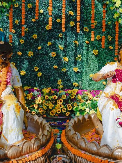 Another angle of the fun-filled Haldi, capturing the bride's laughter as she's covered in turmeric and flower petals.