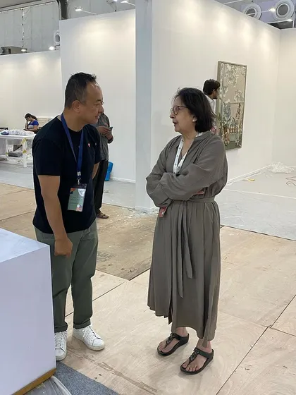 Another shot of the conversation between artist and gallerist amidst the pre-fair chaos.