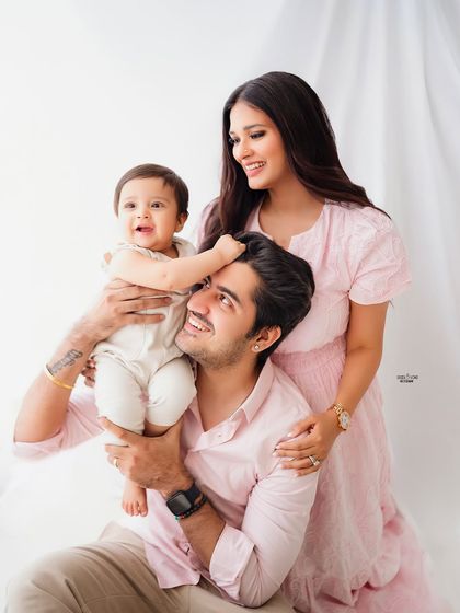 A candid and playful family moment, with the baby reaching for dad's hair.