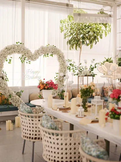 I specialize in creating elegant and romantic atmospheres. This intimate birthday dinner setup features a beautiful heart-shaped arch made of white flowers, surrounded by soft candlelight and classic white and gold decor accents.
