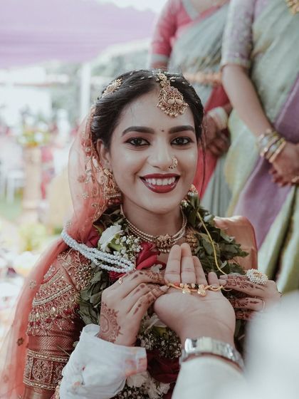 The groom presents the mangalsutra to his bride. Her radiant smile is the centerpiece of this photo, a key moment in any Hindu wedding ceremony.
