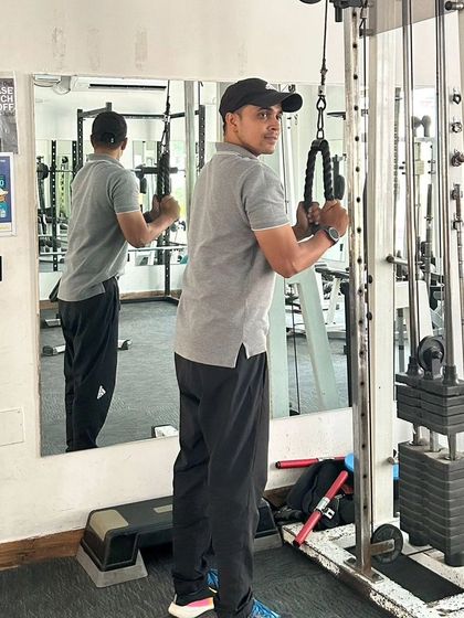 Focused on form during a tricep pushdown exercise at the gym.