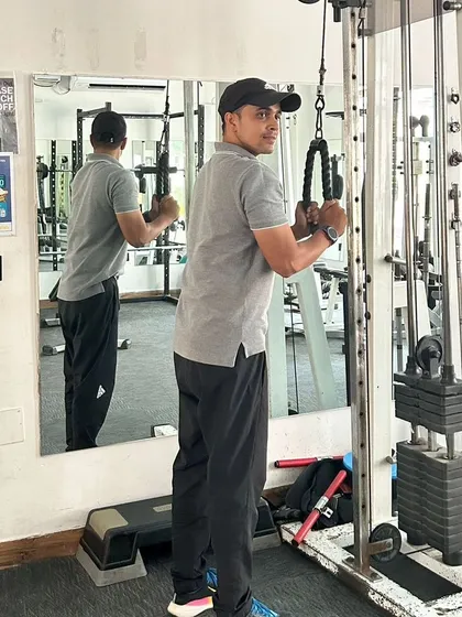 Focused on form during a tricep pushdown exercise at the gym.