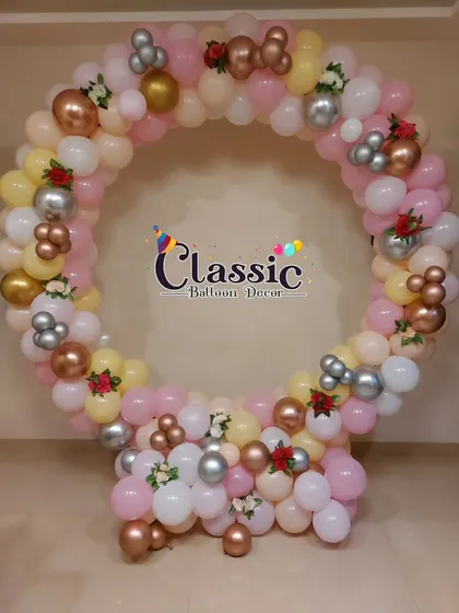 A circular ring photo booth for a naming ceremony, decorated with pastel balloons and small floral accents. This creates a perfect spot for guest photos.
