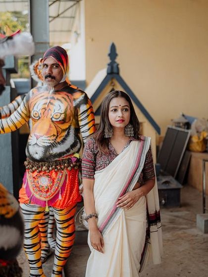 A behind-the-scenes style shot from the Pulikali shoot, showing the interaction between the model and the performers. It adds a layer of story and context to the final images.