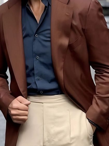 A rich brown blazer paired with a navy shirt and light-colored trousers. This look perfectly blends classic sophistication with modern flair.