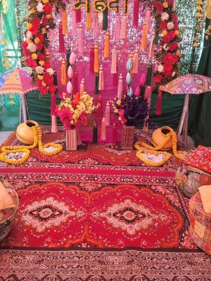 For a truly traditional feel, I offer low seating arrangements with gaddas, bolsters, and printed poufs. This Mehandi setup is complete with matkas, floral arrangements, and colorful umbrellas.
