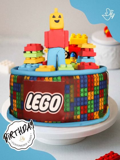 A creative LEGO-themed cake, built with colorful fondant blocks and a LEGO man topper. It's a dream come true for any young master builder.