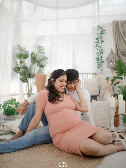 A candid and intimate portrait of an expecting couple, sharing a quiet moment together on the floor of our studio.