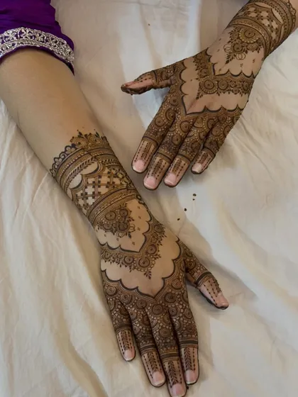 A classic and timeless full-hand design with symmetrical patterns, scalloped edges, and delicate dot work, perfect for any traditional occasion.