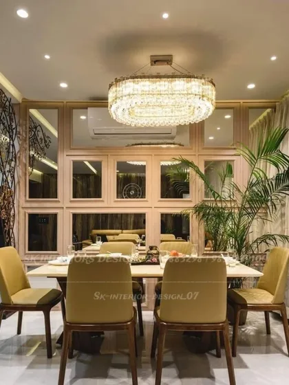 Another angle of the opulent dining room, highlighting the intricate crystal chandelier and the wall of mirrors. The warm tones of the chairs and the natural wood table create a welcoming environment.