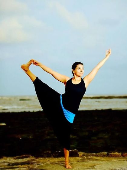 "The world is changed by your example, not by your opinion." A photo of me in a balancing pose by the sea, embodying the principles I teach.