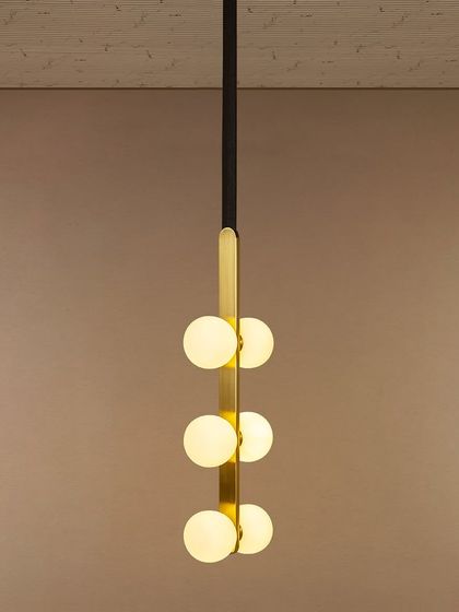 I love this pendant for its modern simplicity. The vertical arrangement of six opal globes on a sleek black and gold spine makes it a perfect lighting solution for stairwells, entryways, or rooms with high ceilings, providing a beautiful cascade of light.