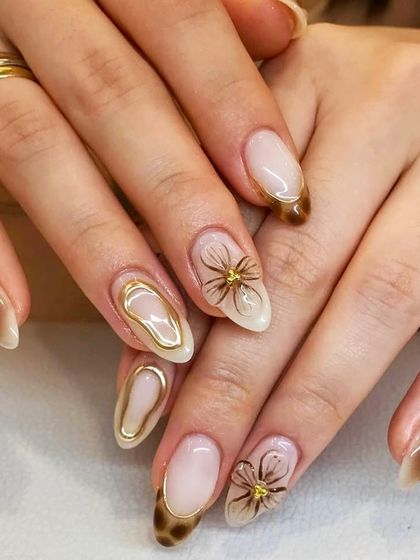 Coffee tones and floral vibes. This luxe set features a brown cat-eye base, gold chrome accents, and delicate, spidery floral designs.