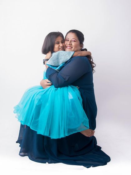 A warm hug between a mother and her daughter. This simple, heartfelt pose against a clean white background creates a timeless portrait filled with love.