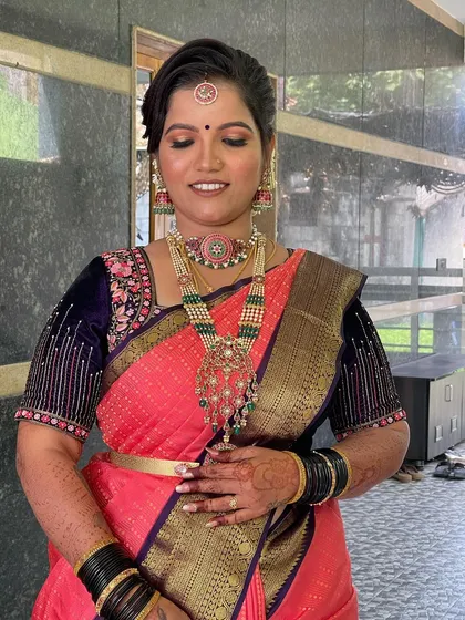 A close-up of her makeup, featuring a soft smokey eye and a warm pink lip, paired with stunning traditional jewellery.
