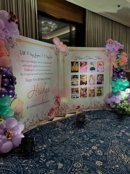 A custom storybook style backdrop displaying photos from the baby's first year, along with a heartfelt message. This personal touch is a favorite among parents.