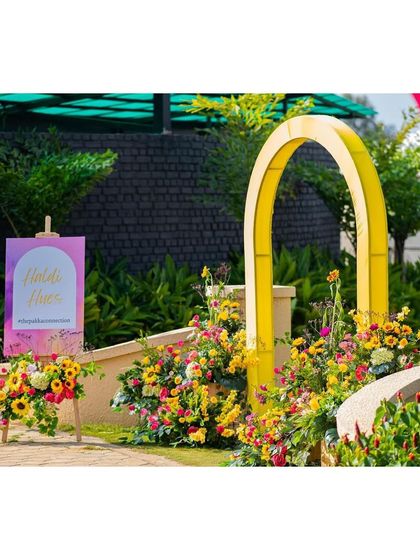 A view through the colorful arches, with the welcome sign and floral arrangements creating a picture-perfect frame.