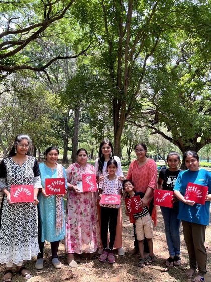 A group photo of our Warli painting workshop attendees, including several children, all proudly displaying their finished canvases. My workshops are designed to be family-friendly and engaging for all ages.