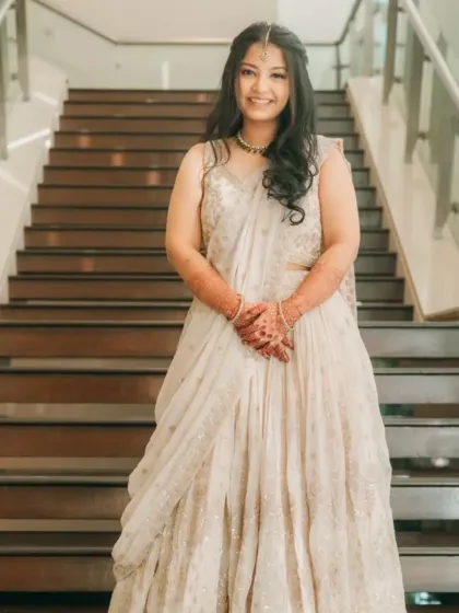 A full-length shot of the bride's sister, looking elegant and poised. The soft makeup and simple hairstyle are perfect for a daytime wedding ceremony.