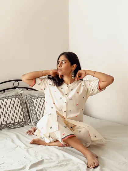 A candid lifestyle image on a bed, capturing a natural moment of the model adjusting her earrings. These shots are effective for social media content as they feel authentic and unposed.
