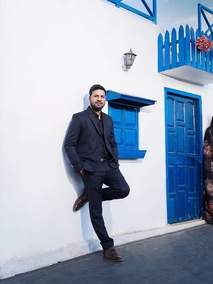 A stylish and modern portrait against the clean lines of the Santorini-themed architecture. This shot has a cool, editorial feel.