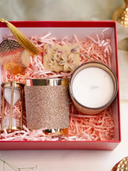A beautifully curated gift hamper is more than just a present; it's an experience. This set includes one of my signature golden glitter candles, a wax sachet, and an hourglass, all elegantly packed and ready to delight.