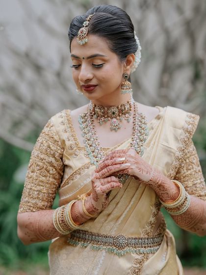 A three-quarter shot showing the intricate details of her jewellery and saree.