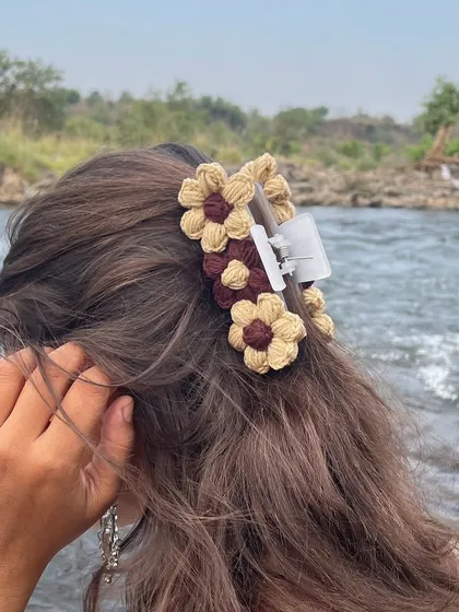 A close-up of the brown and beige floral claw clip, showing how securely it holds the hair. It's both beautiful and functional.