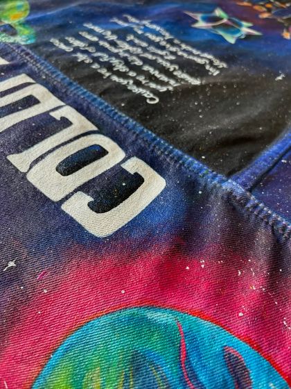 A macro shot of the "COLDPLAY" text painted across the top yoke of the jacket. This shows the clean, bold lettering style I use to make the band's name a central feature of the design.