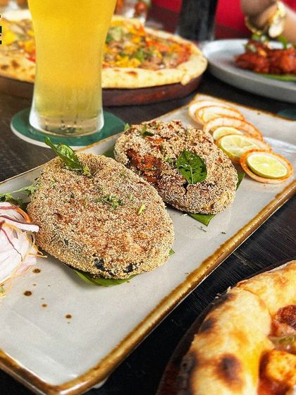 A classic fish fry, golden and crispy, served with fresh onion salad and a slice of lime. It's the perfect companion to a cold beer.