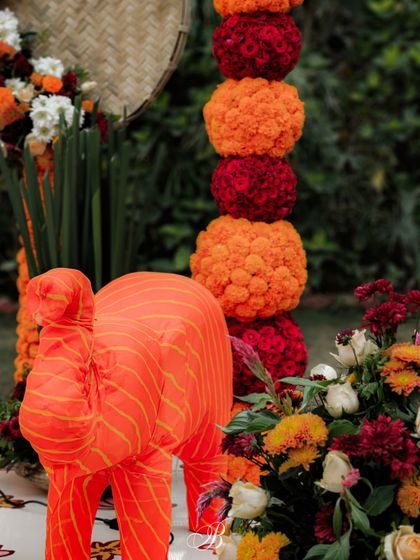 We crafted these charming elephants from scrap fabric, adding a playful and sustainable element to this vibrant photo backdrop. They are paired with marigold towers and bamboo arrangements.