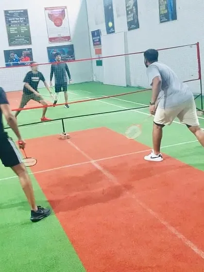 Players getting low and ready for a defensive shot in a competitive doubles rally.