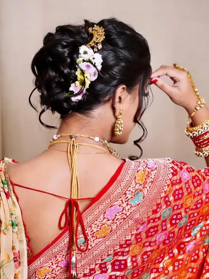 A detailed shot of a messy khopa, showing how wispy strands and carefully placed flowers can create a soft, romantic look.