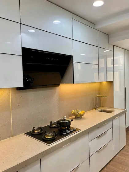The cooking area of a straight laminate kitchen, featuring a modern hob and chimney.
