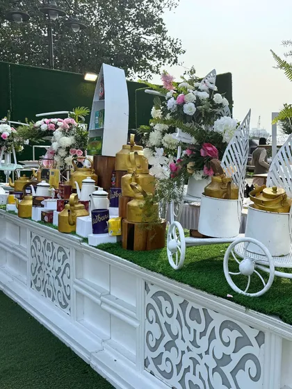 A tea and coffee station featuring an array of traditional brass kettles and modern decor. This setup provides a warm and inviting corner for guests to enjoy a hot beverage.