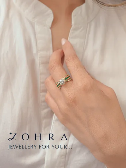 Jewellery for your unique story. This custom ring features a central round diamond, flanked by bands of channel-set emeralds. The combination of green and white against the yellow gold creates a striking, classic look that is deeply personal.