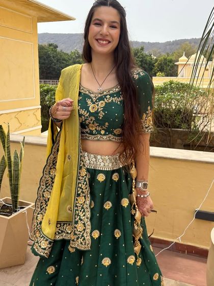 A happy client enjoying a destination wedding in my green and gold embroidered lehenga. It's lightweight, comfortable, and perfect for a daytime event.