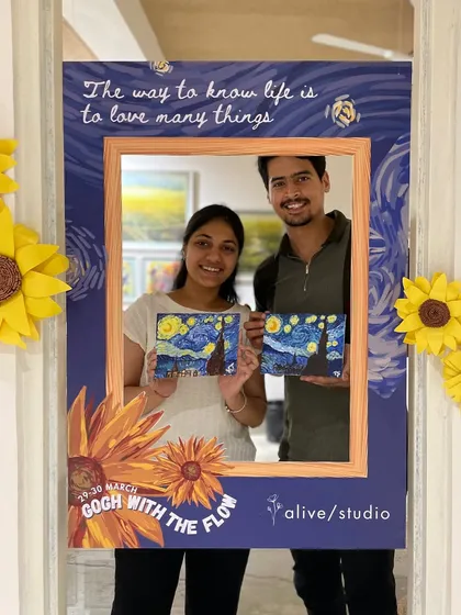 A couple showing off their matching "Starry Night" paintings. Our artist-themed workshops make for a perfect and memorable art date.