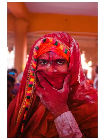An intense portrait from the Holi festival. The layers of red powder and the direct eye contact tell a story of complete immersion in the celebration, a moment where identity is masked by color.
