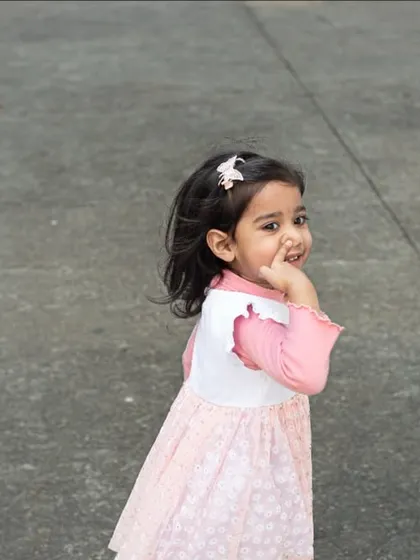 A shy glance back from a little girl during a walk. I capture these fleeting, authentic moments that define childhood.