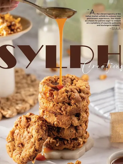 An action shot for Siaa Desert Bakery featuring a stack of cookies with caramel being drizzled on top. This dynamic image, created for a magazine feature, is designed to be mouth-watering and stop the scroll, capturing a moment of pure indulgence.