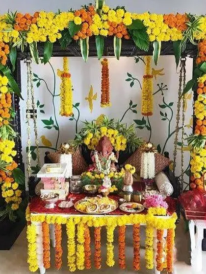 A beautiful Ganpati setup with a jhoola (swing) decorated heavily with yellow and orange marigold flowers.