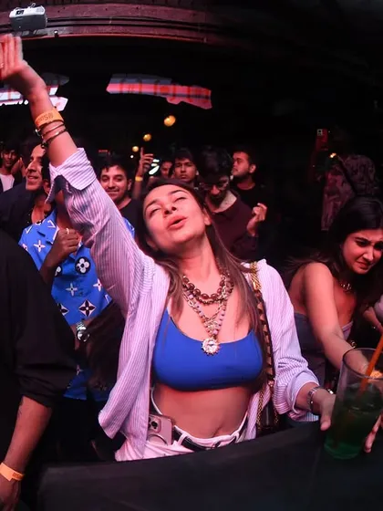 A girl with her hands in the air, completely free on the dance floor.