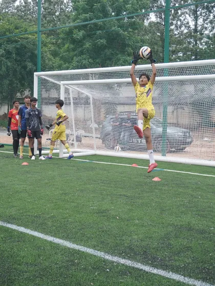 A keeper confidently claims a high ball during a crossing and catching drill. Mastering the ability to command the penalty area is a key focus in our training sessions.
