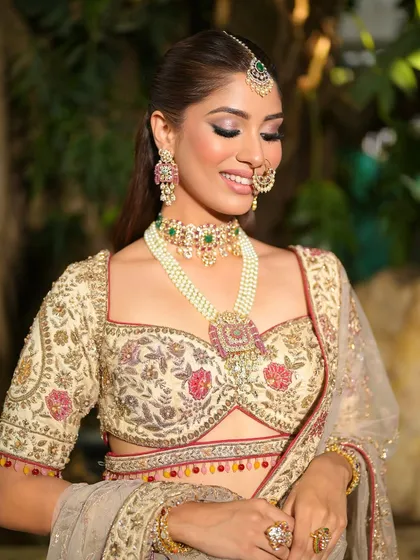 A close-up of the bride looking down, showcasing the soft, shimmery eyeshadow and the intricate details of her jewelry.