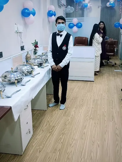 A member of my professional service staff stands ready by the buffet at a corporate event. My team is trained to be attentive, polite, and efficient throughout your event.